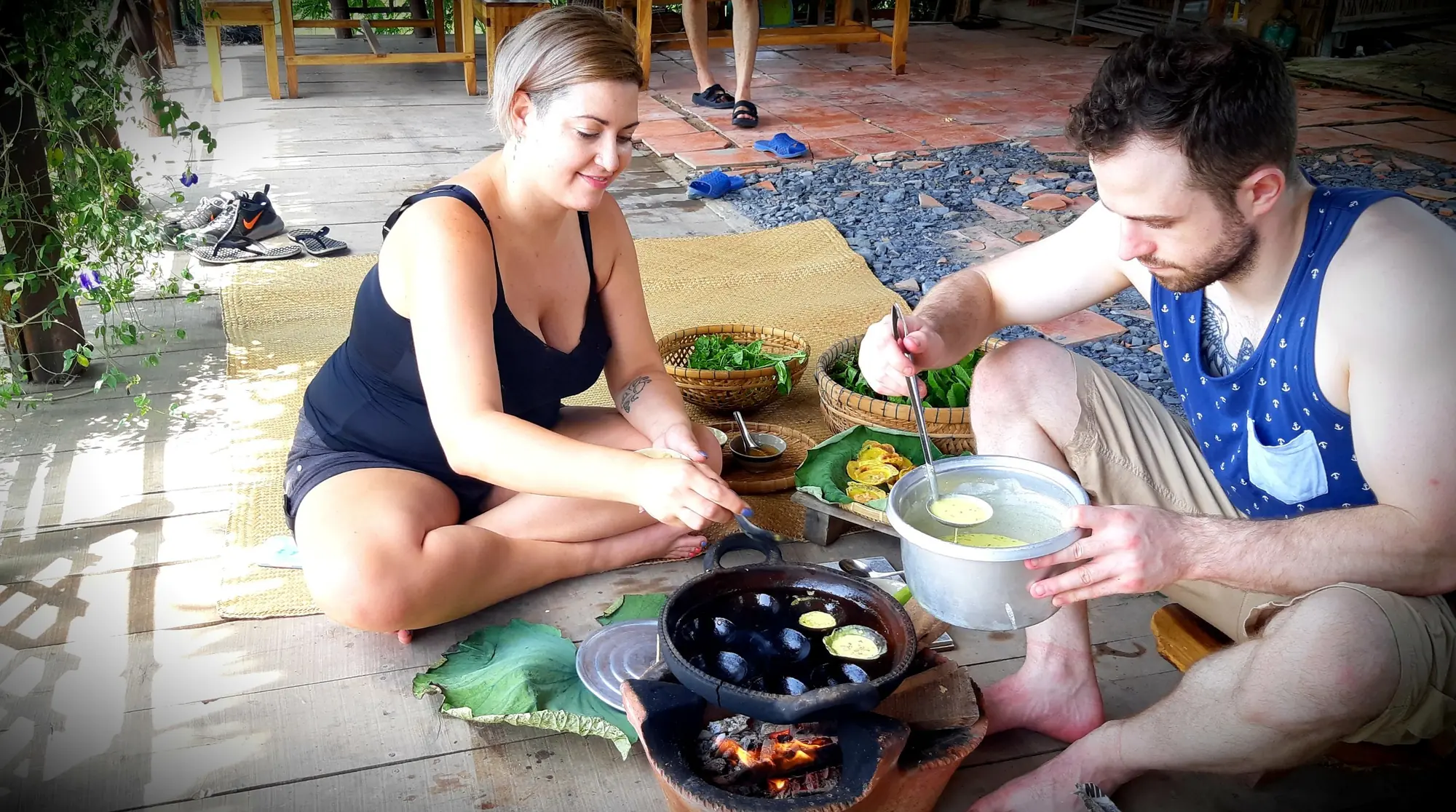 Guests making lotus cakes on a traditional stove