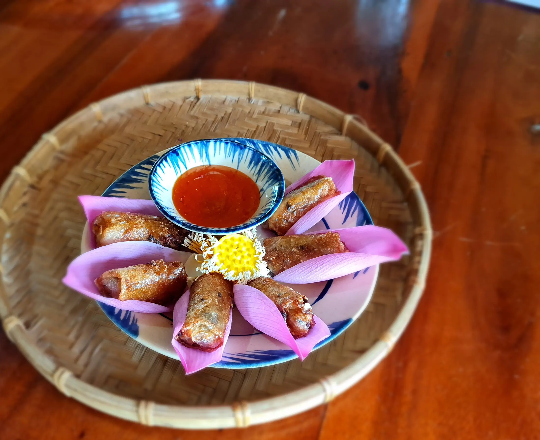 Fresh spring rolls arranged with herbs and lotus petals