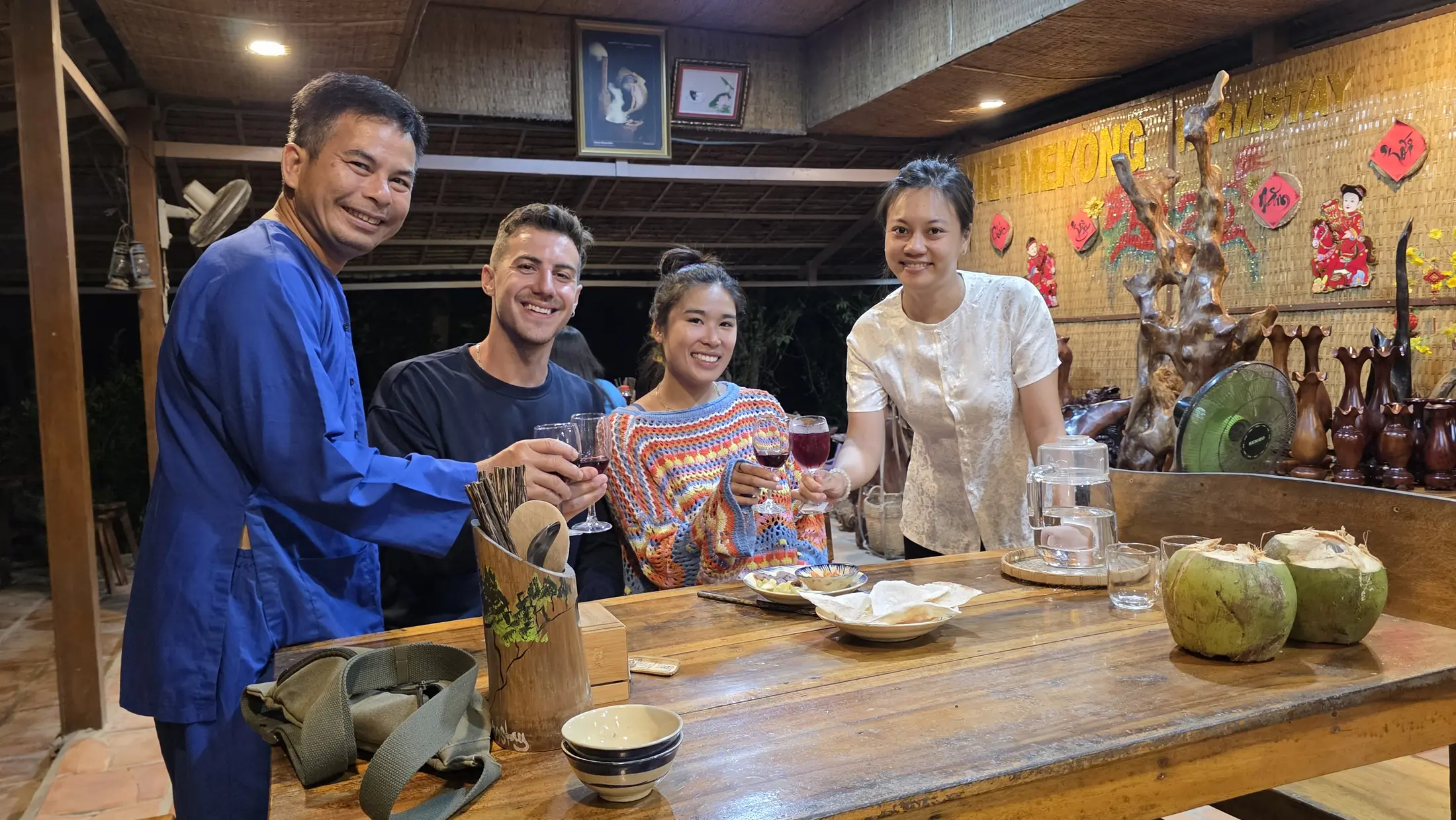 Adult guests and their host sharing a local meal at Việt Mekong Farmstay