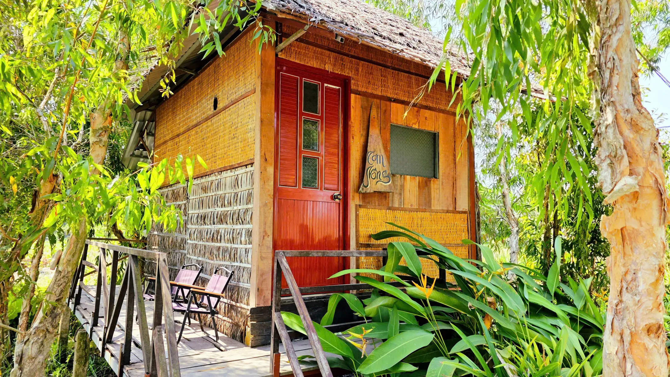 Private bungalow with a red door beneath wetland trees